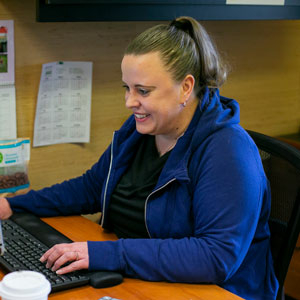 Women smiling at desk with fingers on keyboard
